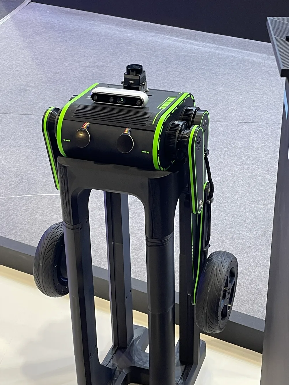 A black-and-green wheeled robot base carrying a depth camera and a lidar