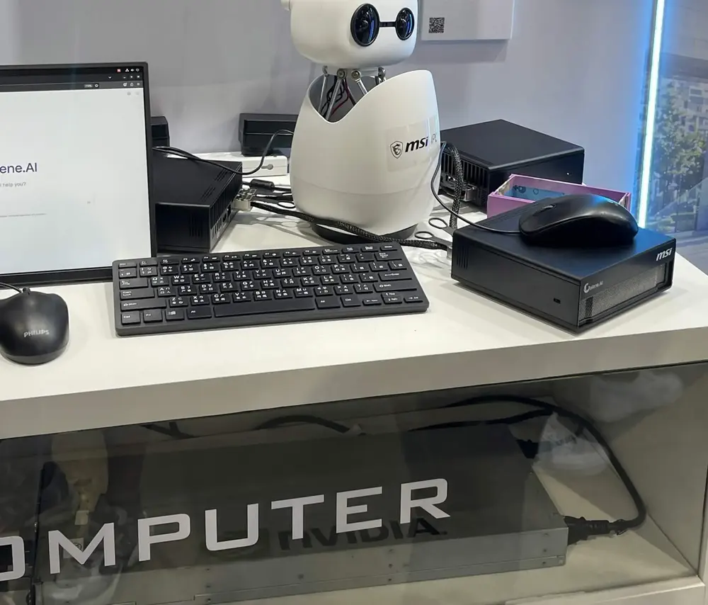 A white Reachy Mini desktop robot next to a keyboard and a mini PC