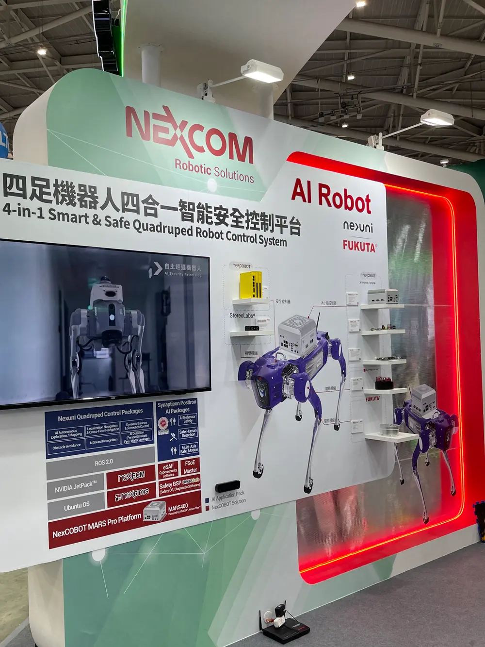 A NEXCOM booth board for a 4-in-1 smart and safe quadruped control platform, with two purple quadrupeds mounted beside it