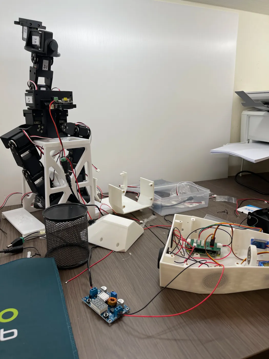 The build desk: the skeleton next to a step-down module, the white head shell, and cables