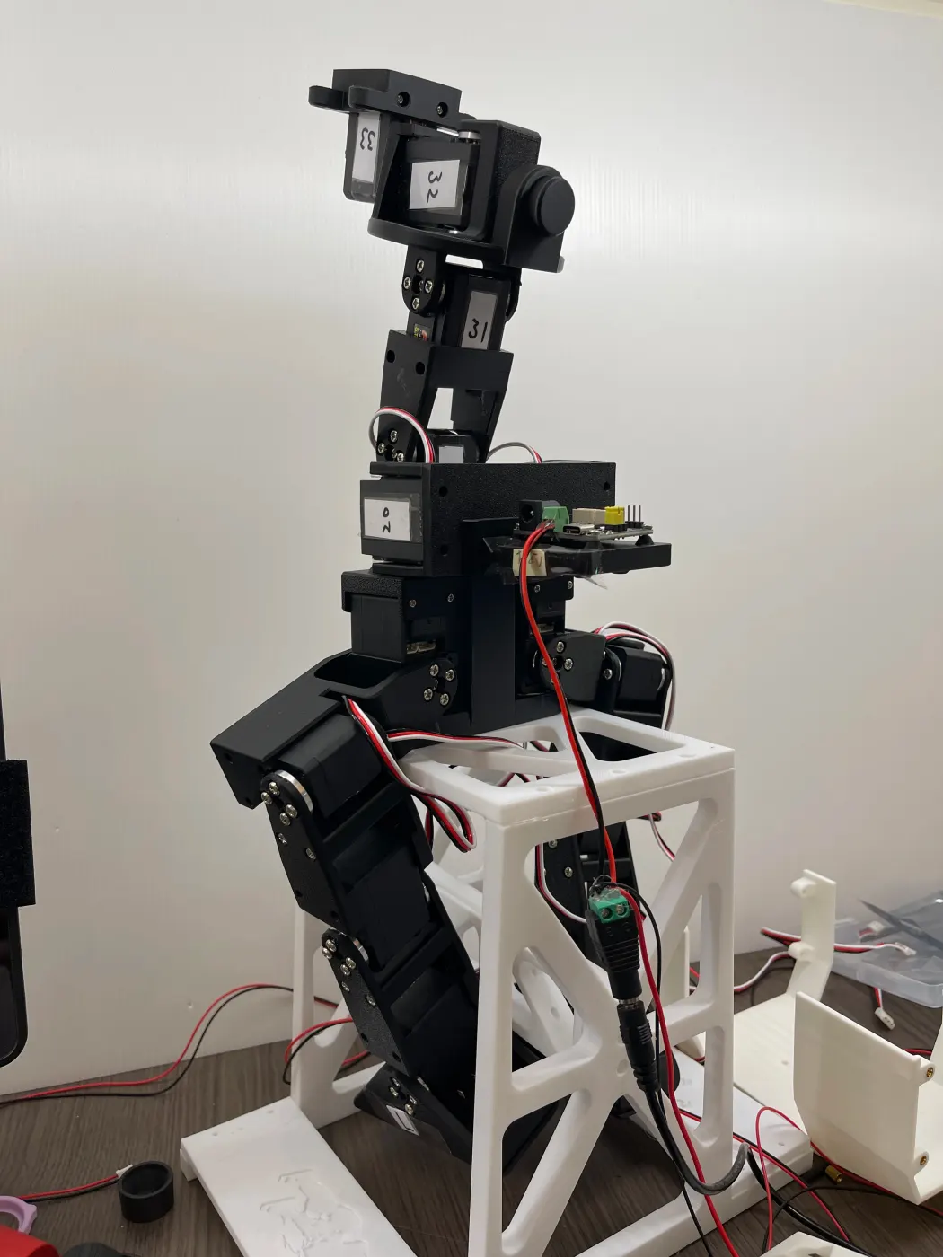 The skeleton on a white 3D-printed stand, next to the control board and cables