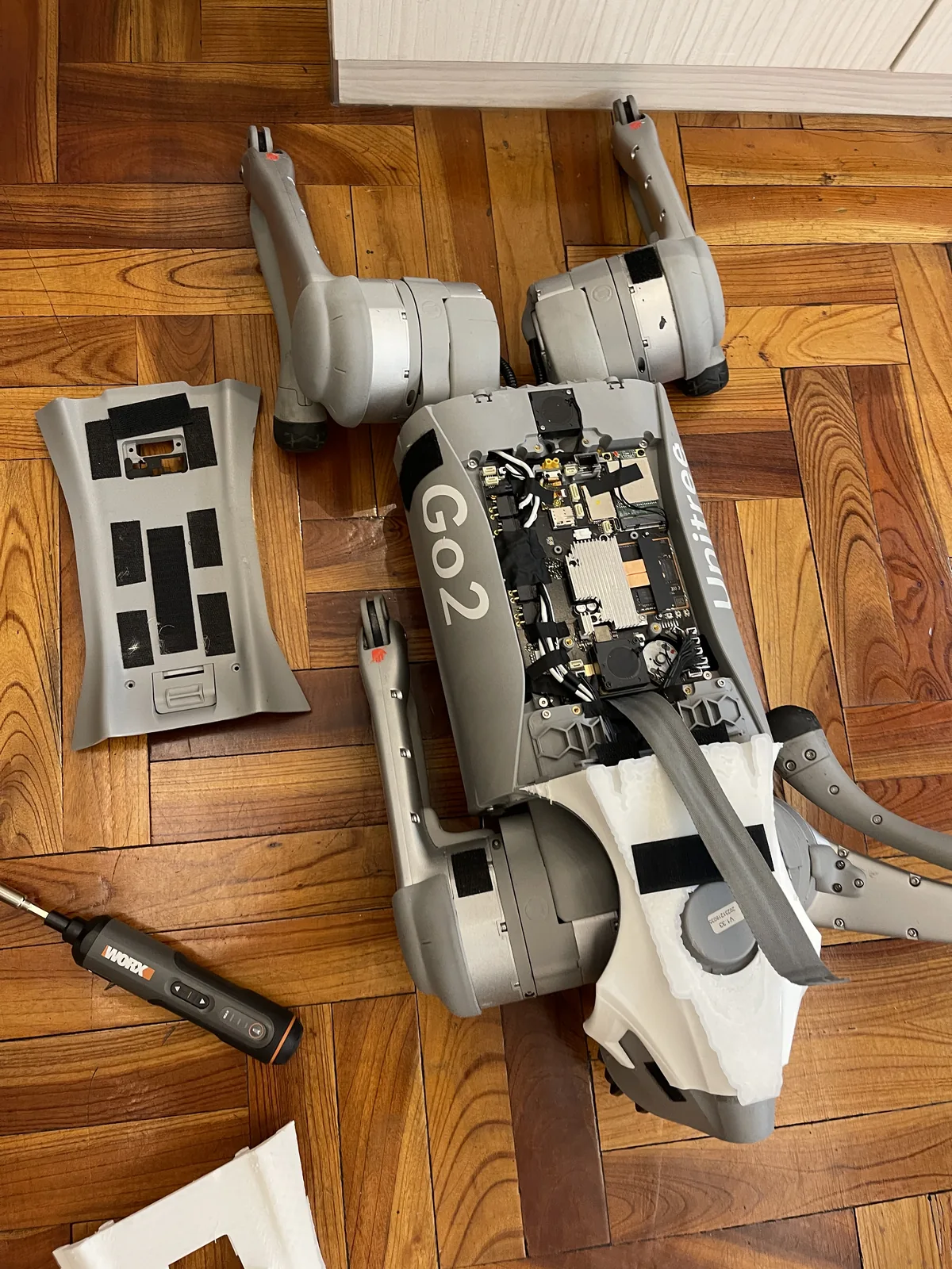 The Go2 top shell removed while working through internal cables, connectors, and mounting points