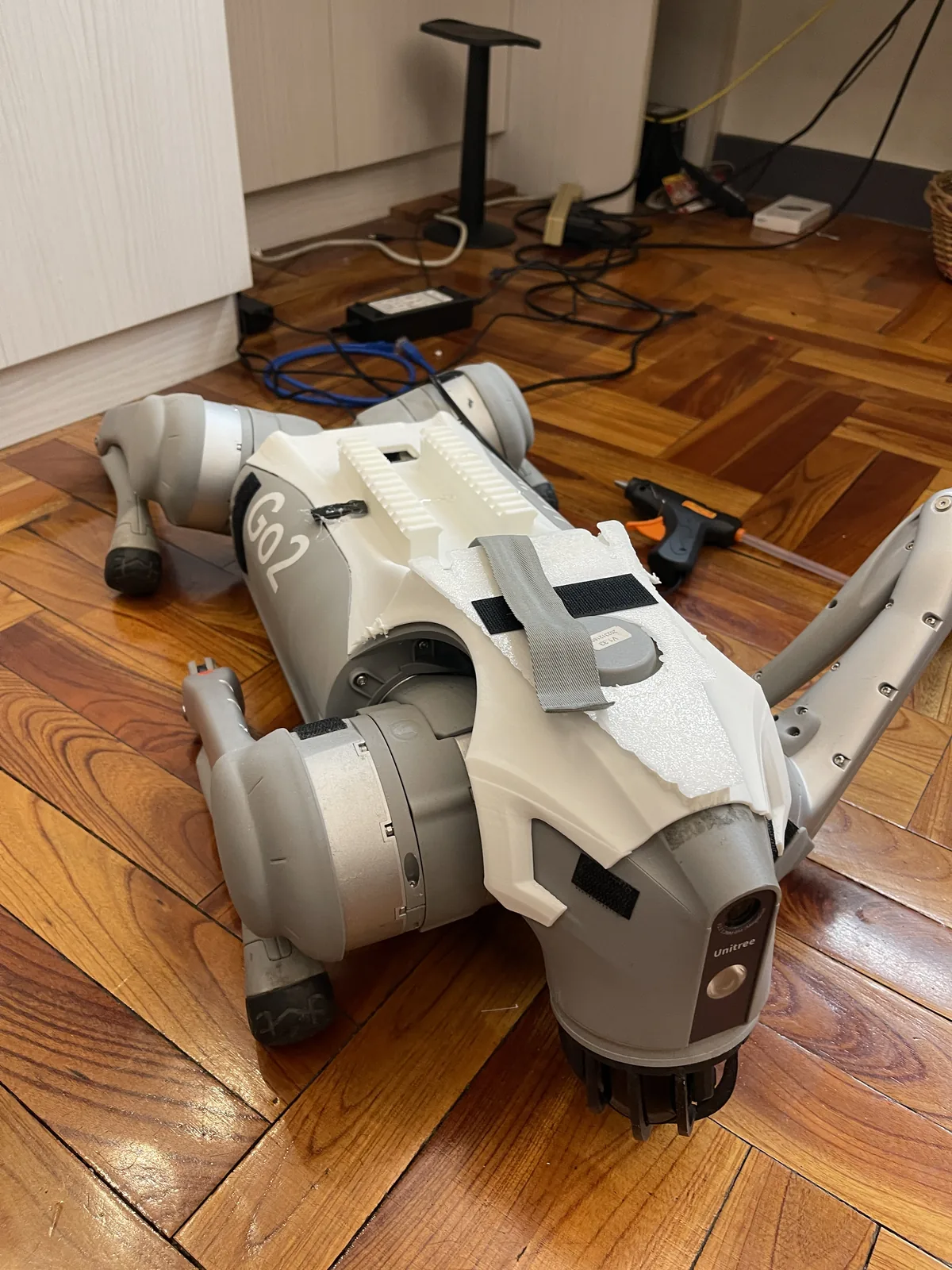 The Go2 fitted with the white custom back cover I 3D-printed, with Velcro and straps providing removable payload mounts